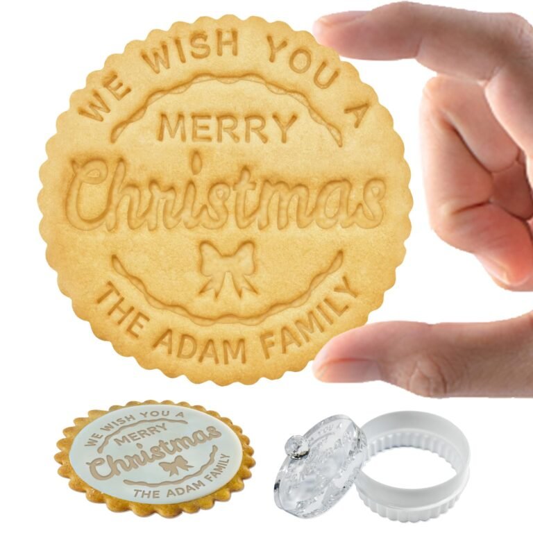 Person holding a Christmas cookie with "Merry Christmas" and "The Adam Family" embossed