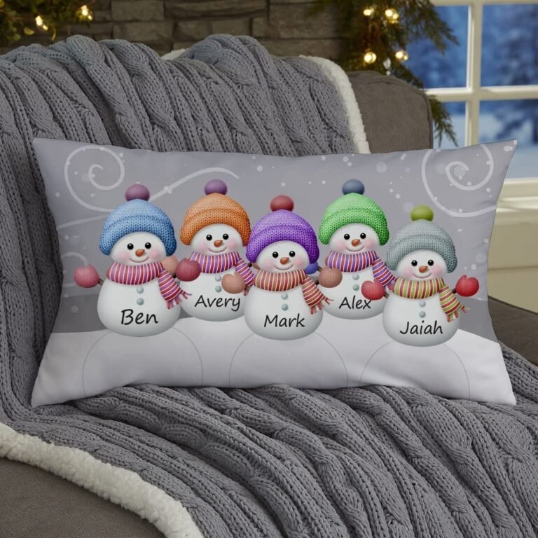 Pillow with five snowmen, each with a name, on a gray blanket